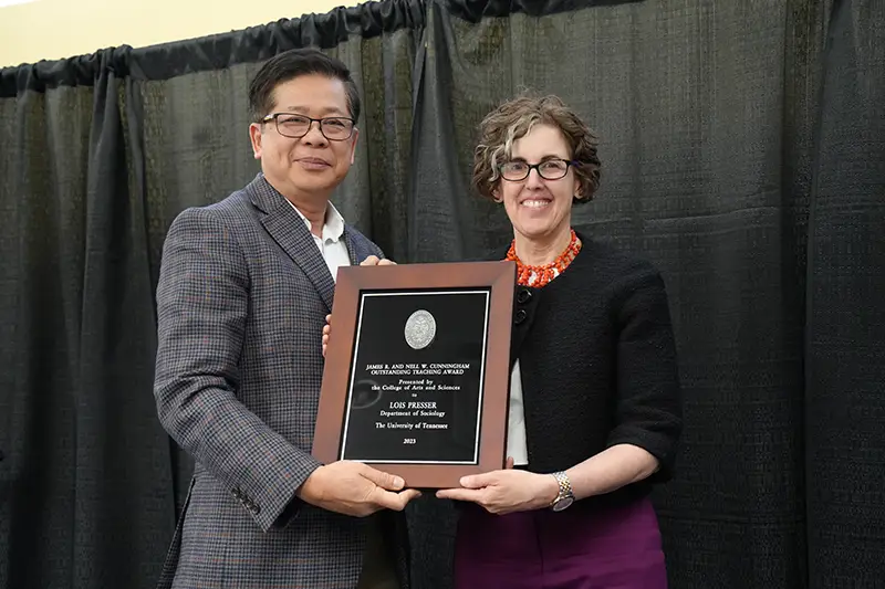 Lois Presser is presented with an award by Liem Tran at the Faculty Awards Convocation.