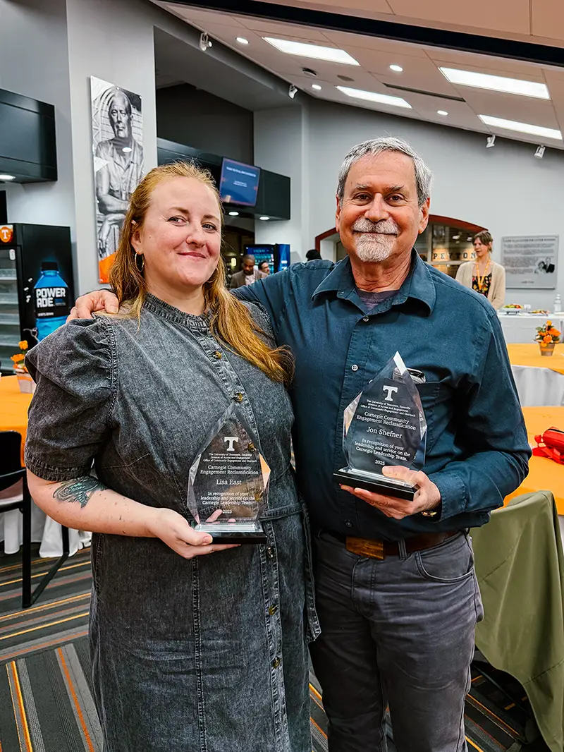 Lisa East and Jon Shefner hold awards.
