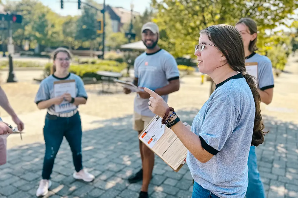 Megan Conley works with a group of students from the Justice Studies certificate program. They are outside on UT's campus.